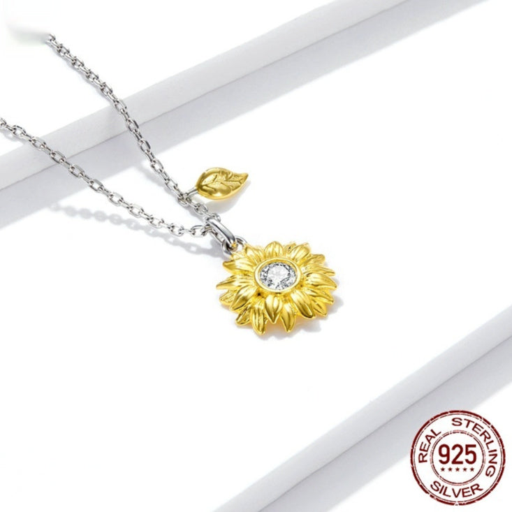Gold sunflower pendant necklace with silver chain on a white background, featuring a 'Real Sterling Silver' stamp.