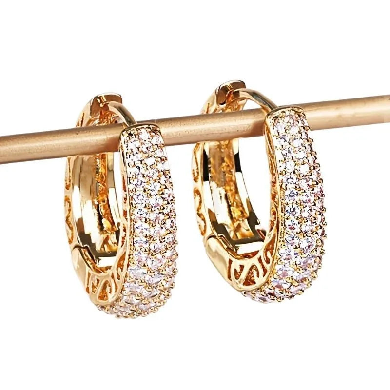 Detailed view of gold-plated hollow hoop earrings paved with cubic zirconia