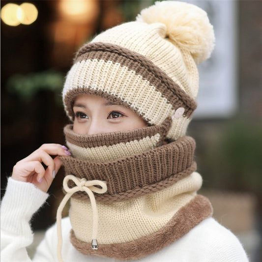 Person wearing a beige and brown knitted hat and scarf set with a blurred background