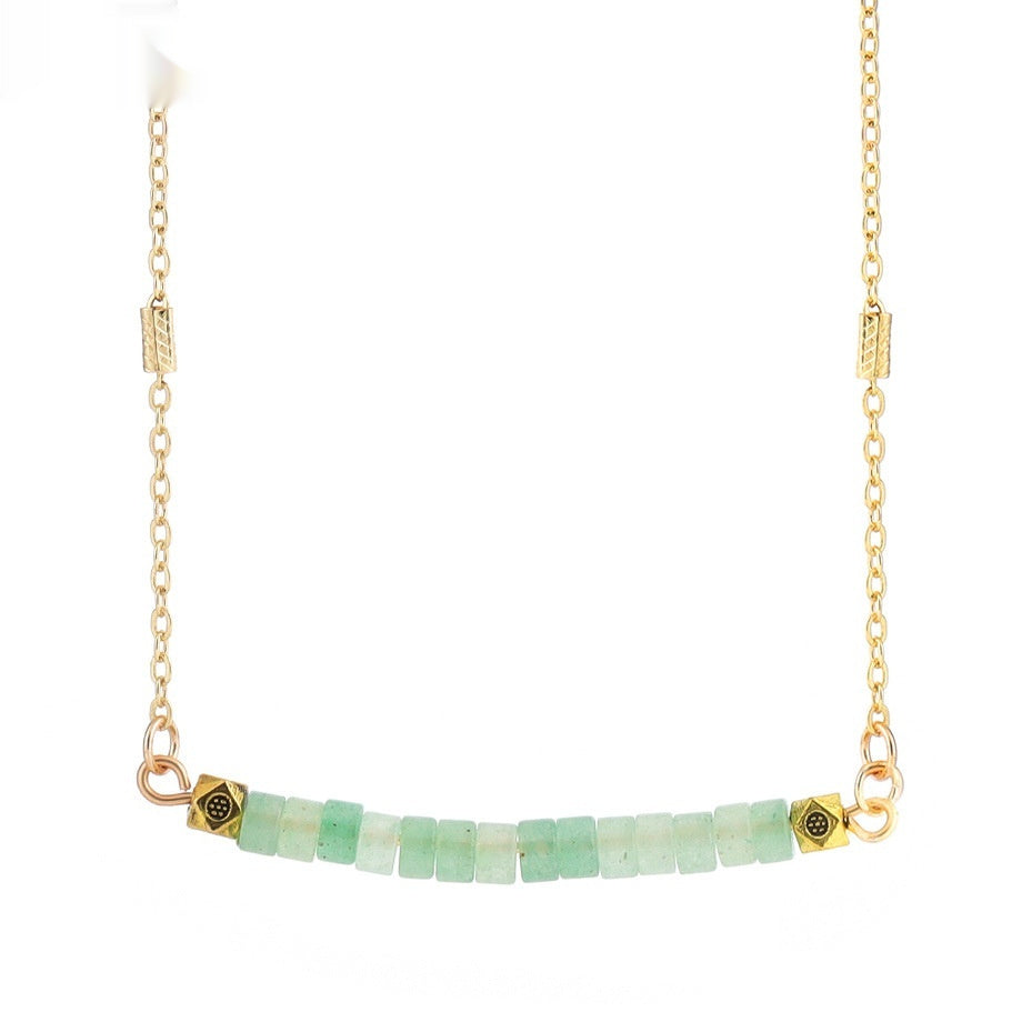 Gold necklace with green beads on a white background