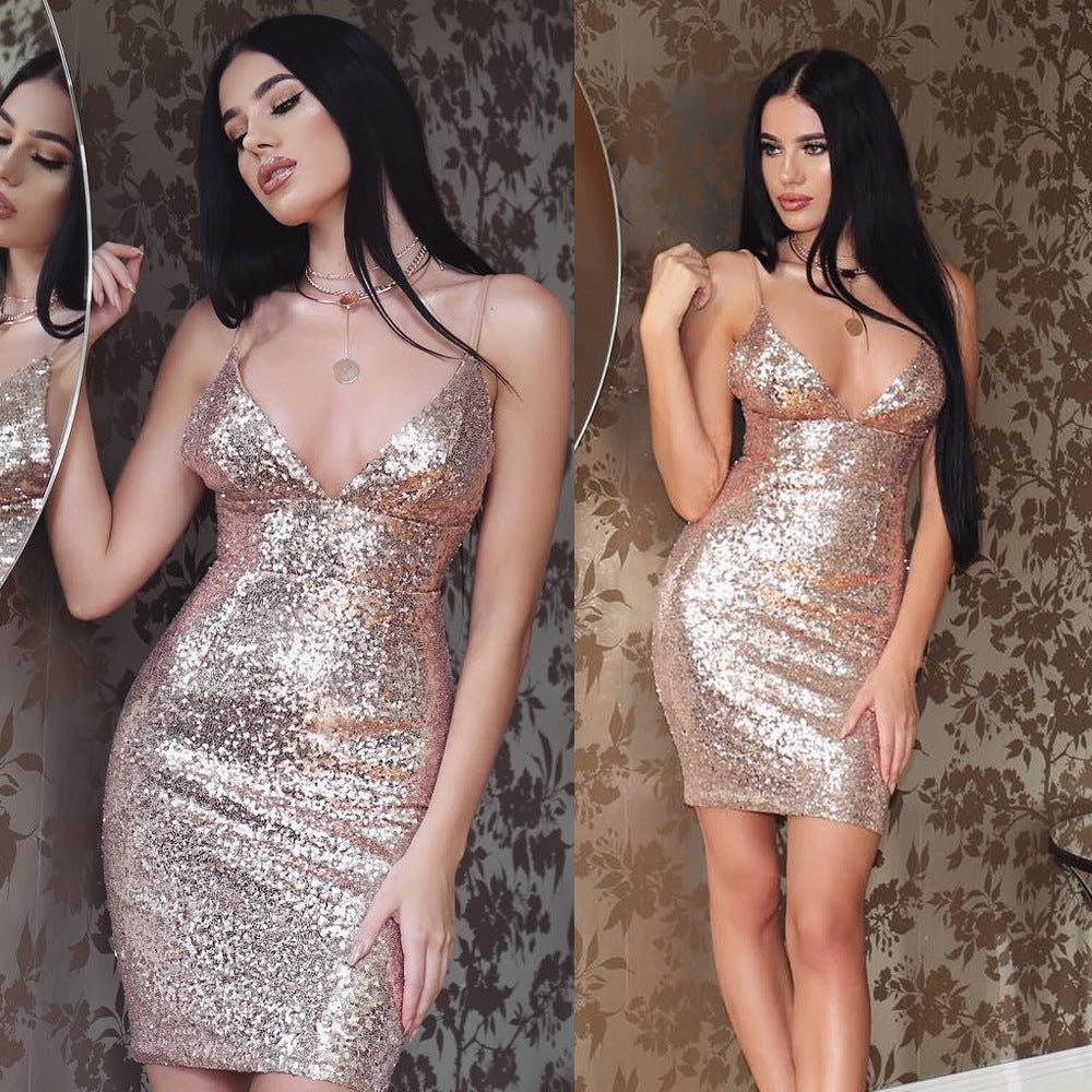 Woman wearing a sparkly gold dress against a patterned wall.