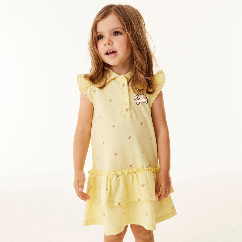 Young girl wearing a yellow dress with a small design on a white background