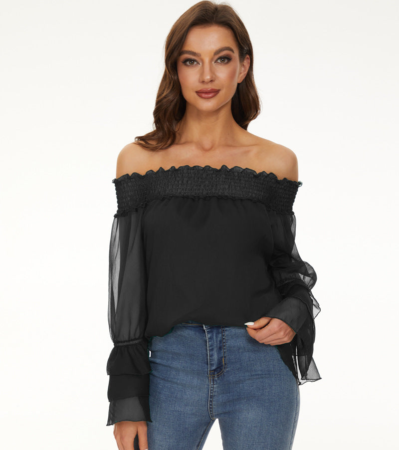 Woman wearing a black off-shoulder top with sheer sleeves on a white background