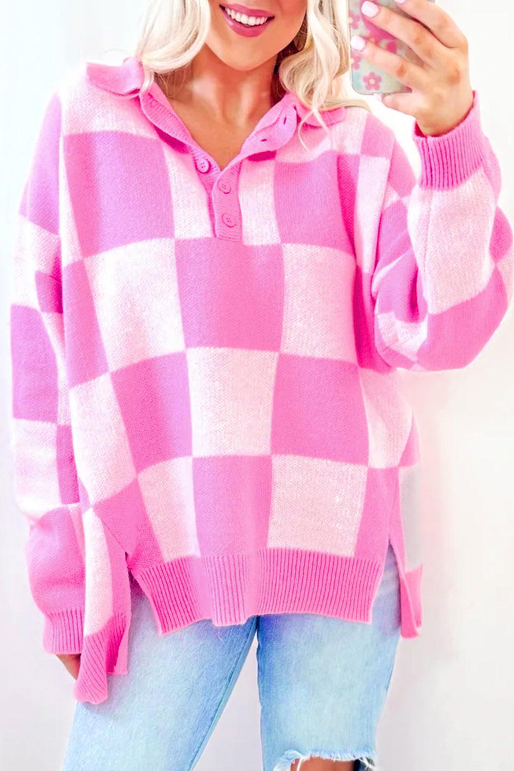 Pink checkerboard collared sweater with half-button detail and drop shoulders.