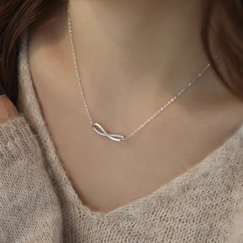 Woman wearing sterling silver infinity necklace – light luxury daily jewelry