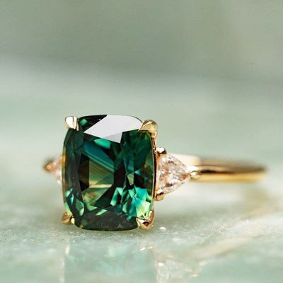 Ring with a green gemstone on a light background