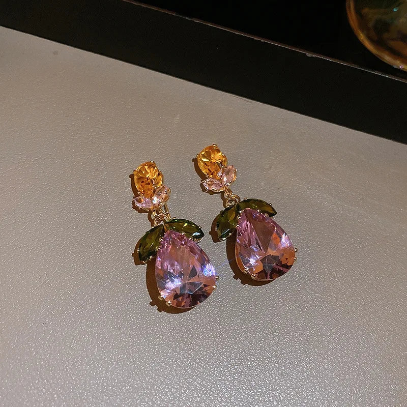 Detailed view of gold flower leaf earrings with water-drop zircon pendant