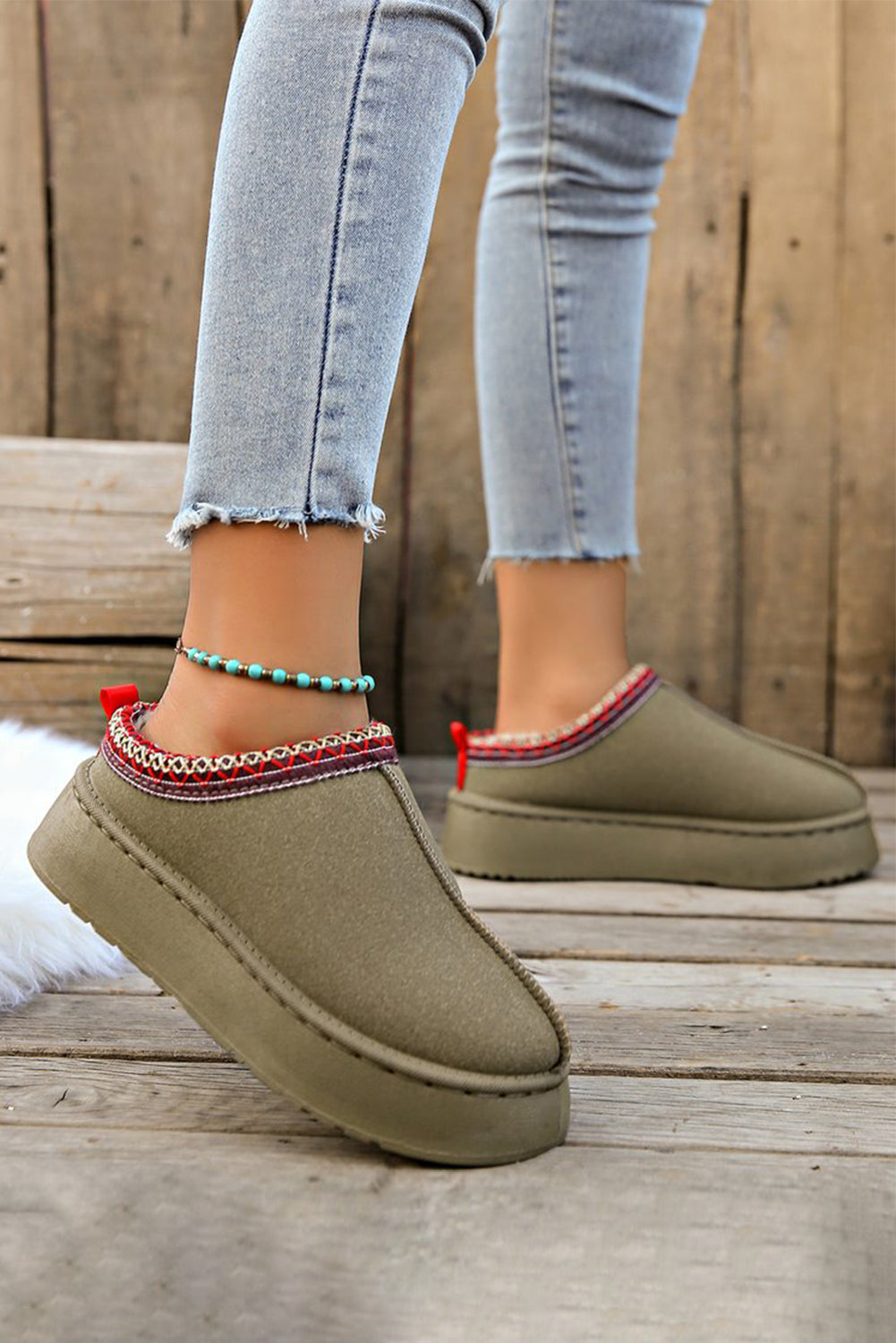 Woman wearing sage green suede snow boots – chic winter outfit with cozy comfort