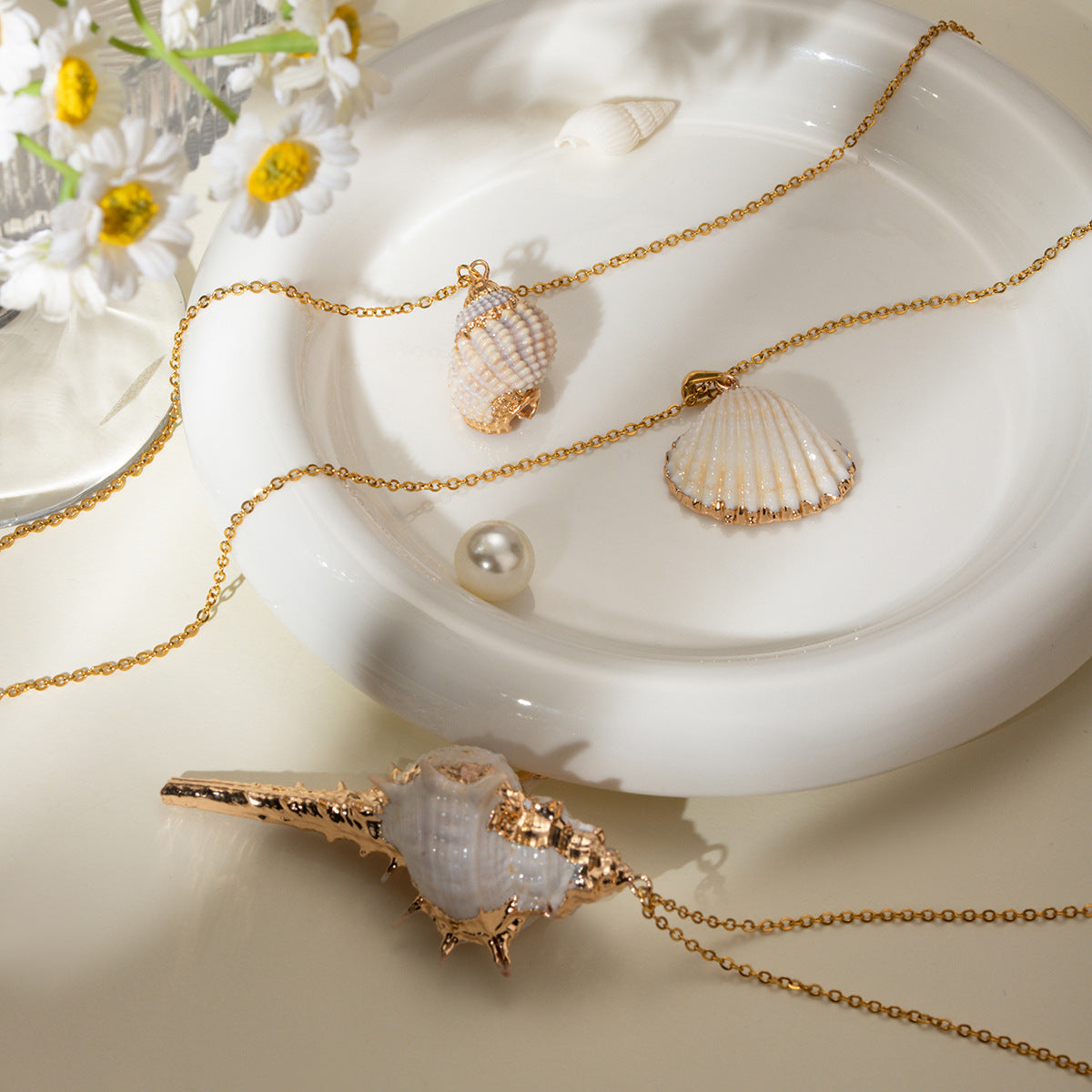 Gold plated shell pendant necklace with stainless steel chain and beach style conch charm.