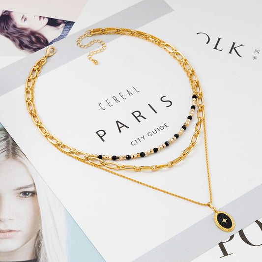 Gold layered necklace with black enamel star pendant and multi-chain vintage design for women.
