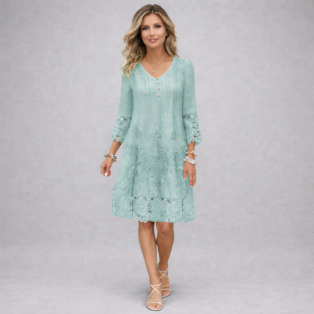 Woman wearing a light blue dress with lace details on a gray background