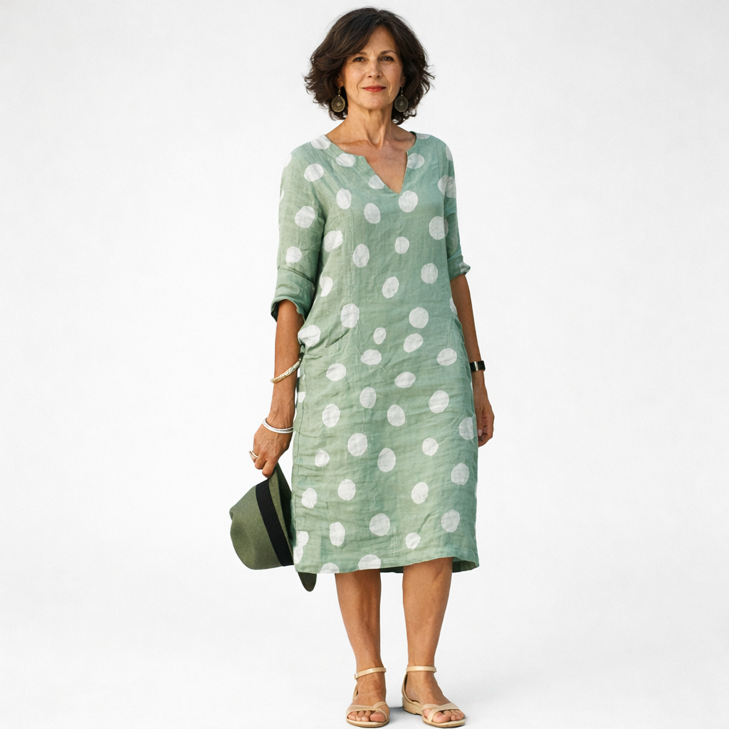 Woman wearing blue linen polka dot V-neck midi dress with relaxed casual fit.
