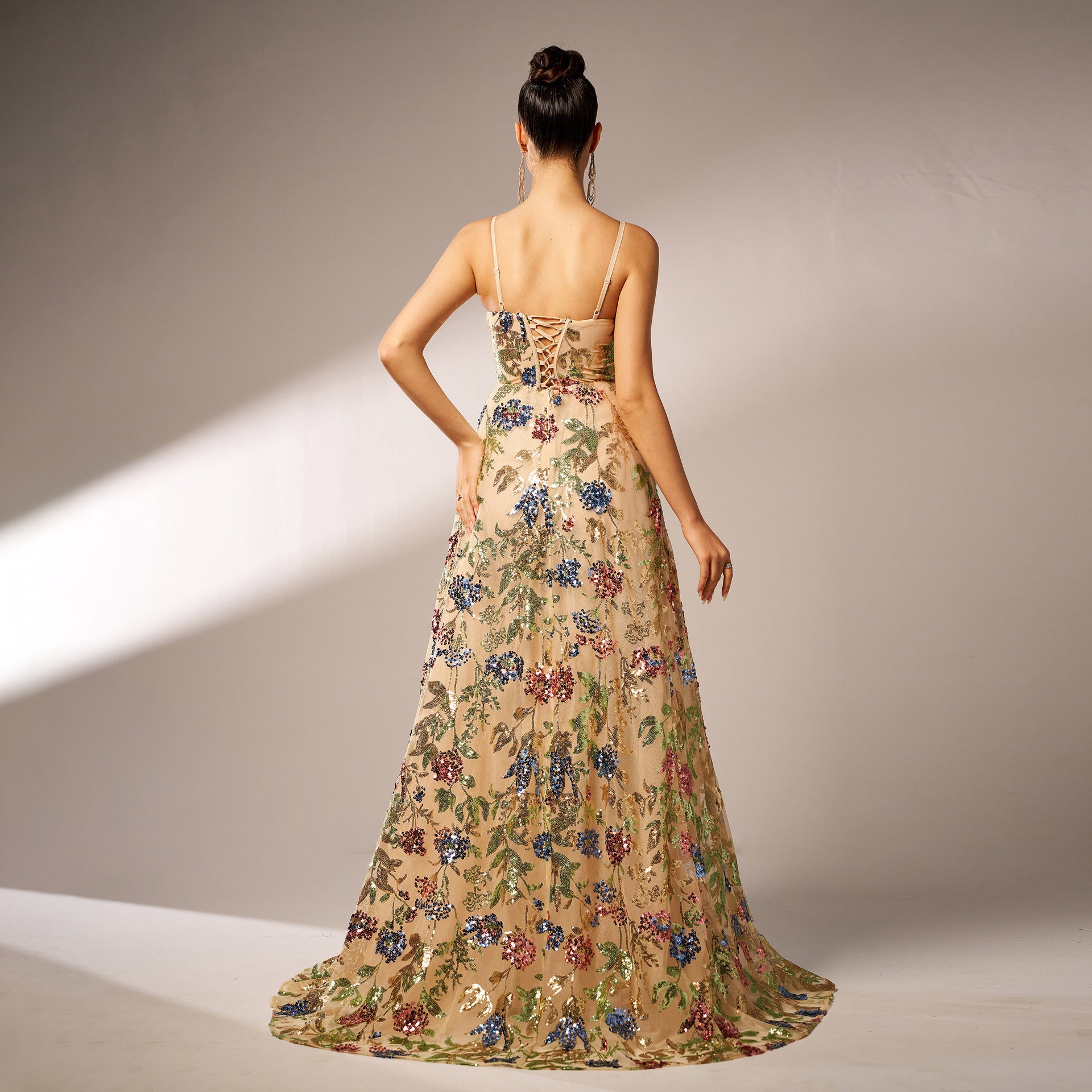 Woman wearing a floral evening gown against a neutral background
