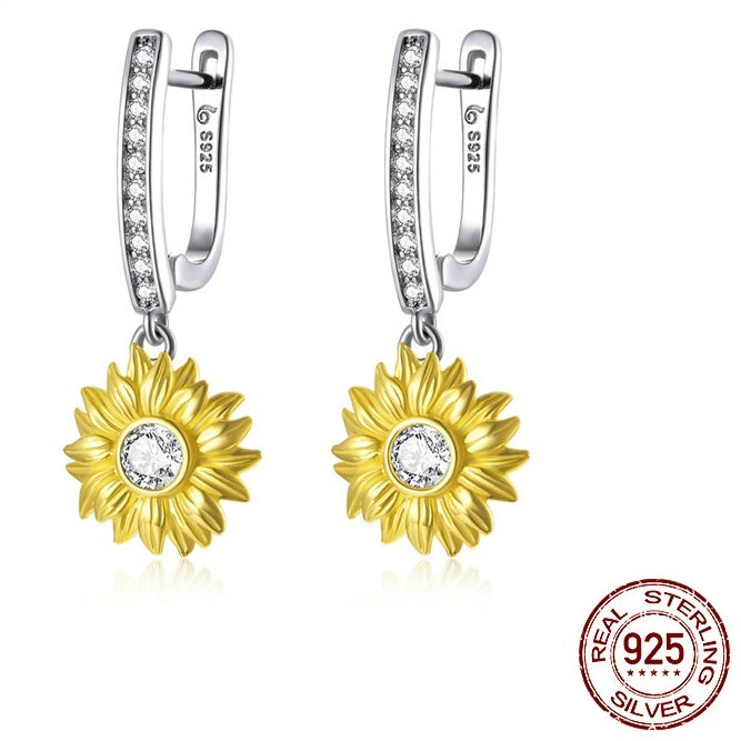 Gold sunflower earrings with clear stones on silver hooks, featuring 'Real Sterling Silver' stamp.
