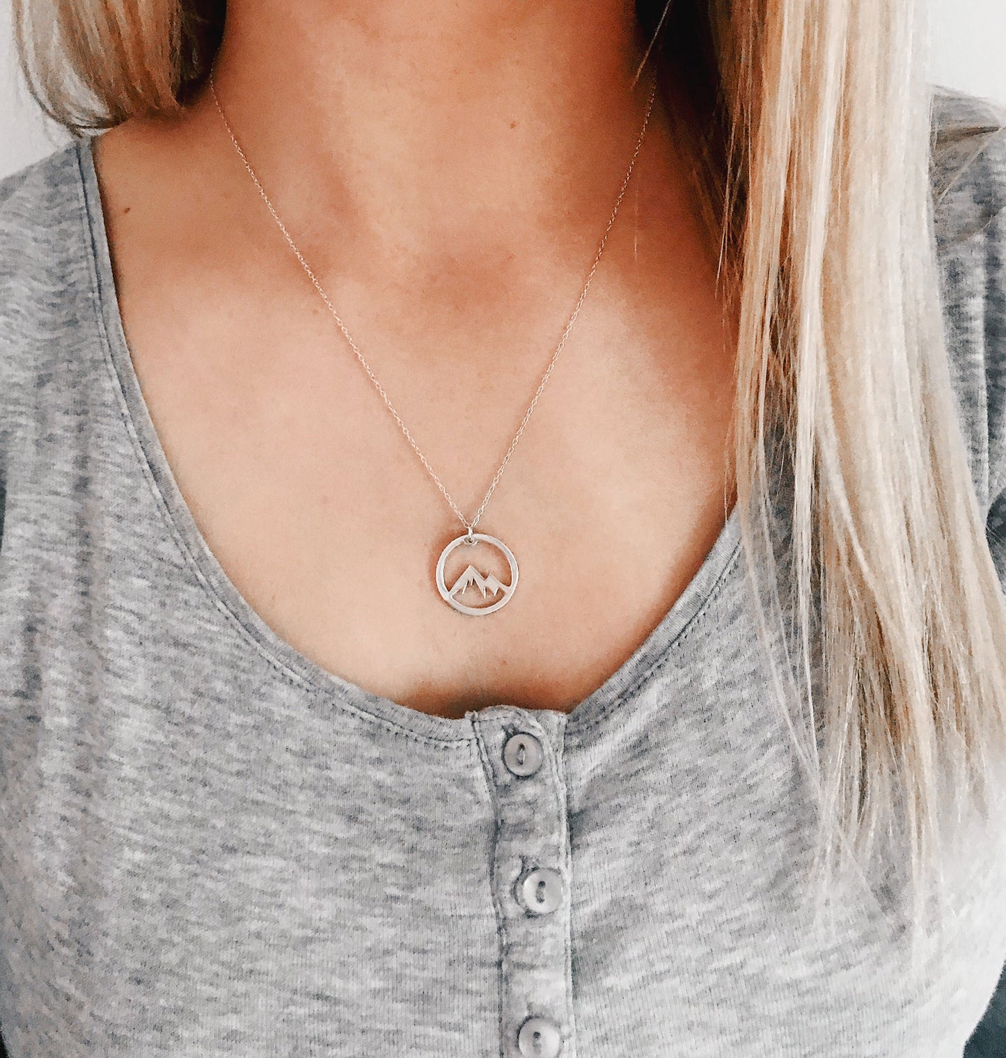 Woman wearing minimalist silver mountain necklace inspired by nature
