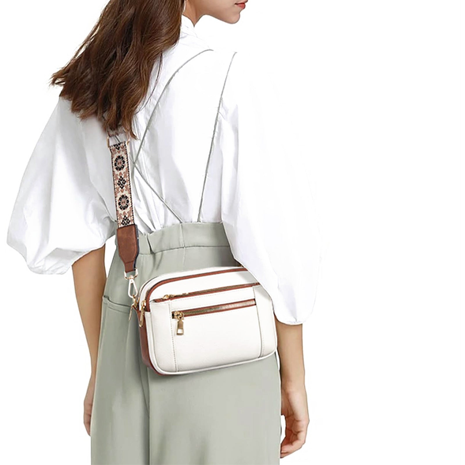 Person wearing a white blouse and light green skirt with a white crossbody bag.