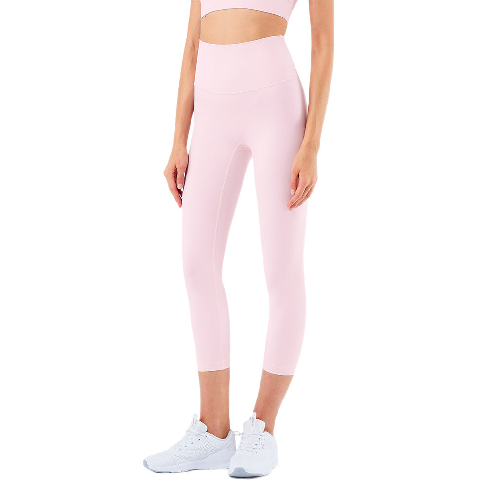 Person wearing pink leggings and white sneakers on a white background