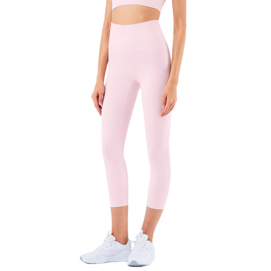 Person wearing pink leggings and white sneakers on a white background