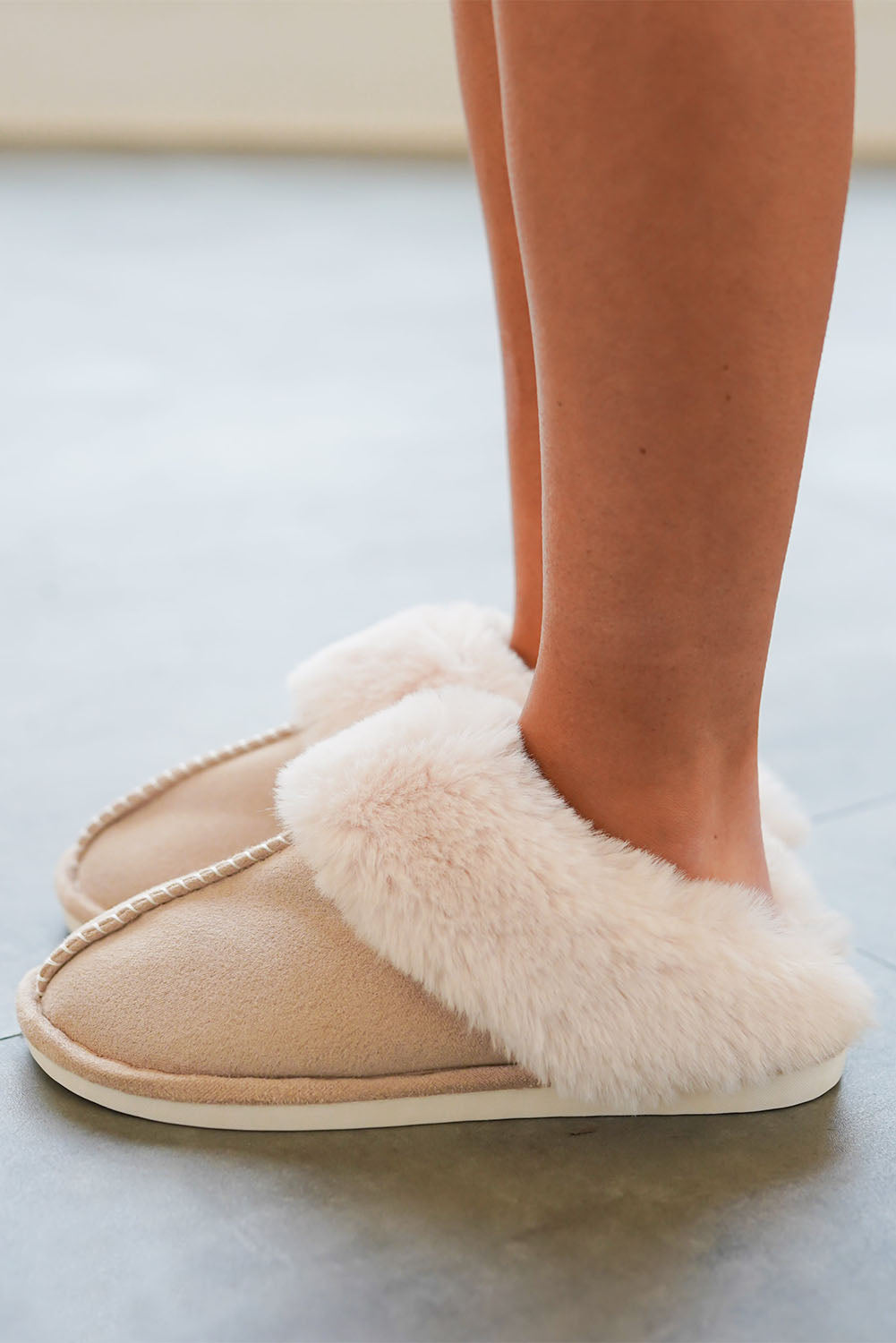 Woman wearing khaki slippers at home – warm and stylish indoor comfort.