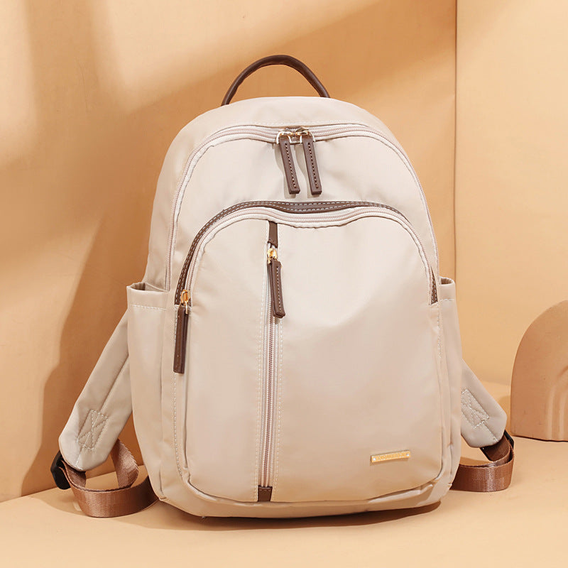 Lightweight women’s beige minimalist backpack with multiple zip compartments in two size options