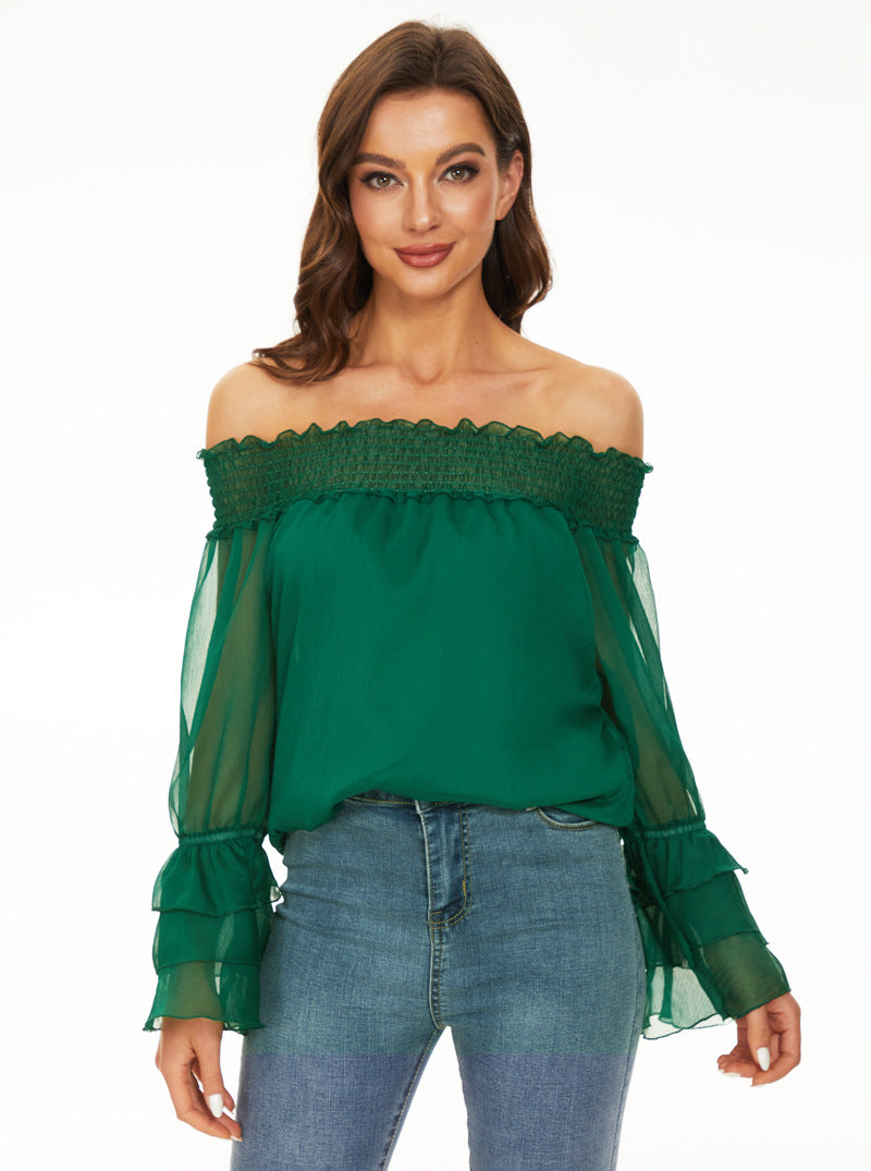 Woman wearing a green off-shoulder top with sheer sleeves on a white background